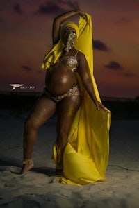a woman in a yellow dress posing on the beach